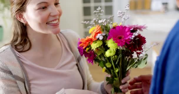 Ευτυχισμένο Ζευγάρι Που Δίνει Λουλούδια Και Αγκαλιάζει Στο Σπίτι Αργή — Αρχείο Βίντεο