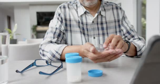Starszy Dwurasowy Mężczyzna Lekami Który Rozmawia Lekarzem Przez Video Tablecie — Wideo stockowe