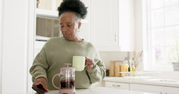 Glad Afrikansk Seniorkvinna Dricker Kaffe Använder Smartphone Soligt Kök Slow — Stockvideo