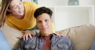 Mutlu çift portresi kanepede oturuyor ve evde kucaklaşıyorlar, ağır çekimde. İlişki, birliktelik, yaşam tarzı ve aile hayatı değişmedi..