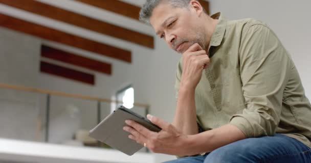 Bedachtzame Oudere Biracial Man Zit Tafel Met Behulp Van Tablet — Stockvideo