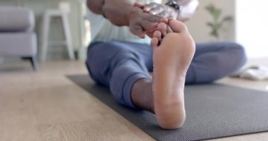 Afrika kökenli Amerikalı bir adamın, güneşli oturma odasında gerinmesi, ağır çekim. Ev, egzersiz, fitness ve sağlıklı yaşam tarzı, değişmemiş..