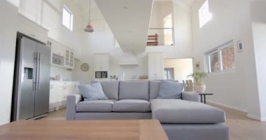 Gri kanepe, buzdolabı, mobilyalar ve güneşli evdeki pencereler. İç tasarım, ev ve ev hayatı.