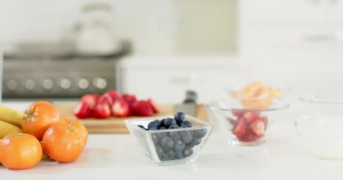 Güneşli mutfakta beyaz tezgahta duran lezzetli renkli meyveler. Meyveler, vitaminler, beslenme, refah ve sağlıklı yaşam tarzı..