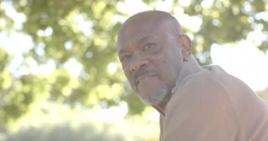 Evdeki balkonda, ormanın üstünde, yaşlı, çift ırklı mutlu bir adamın portresi, ağır çekim. Ev hayatı, emeklilik ve yaşam tarzı, değişmedi..