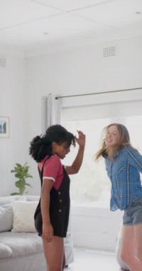 Evde dans eden çeşitli kadın arkadaşlarının dikey videosu, yavaş çekim. Aile hayatı, arkadaşlık ve yaşam tarzı, değişmedi..