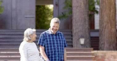 Güneşli bahçede konuşan ve el ele tutuşan mutlu son sınıf çifti. Emeklilik, dinlenme, boş zaman, birliktelik ve doğa konsepti, değiştirilmemiş..
