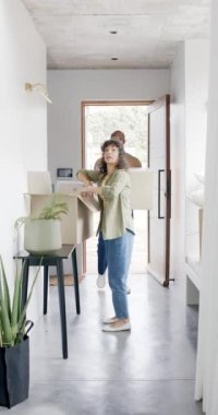 Eve taşınan mutlu ve olgun çiftin dikey videosu, ağır çekimde. Ev, taşınma, mülkiyet, ilişki, birliktelik, ev hayatı ve yaşam tarzı, değiştirilmemiş..