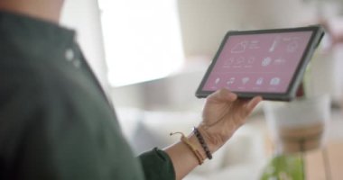 Evde akıllı evi olan, ağır çekimde çift cinsiyetli bir adam tablet kullanıyor. Ev hayatı, teknoloji ve yaşam tarzı, değişmedi..