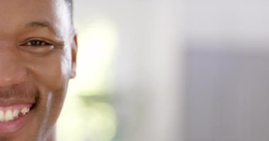 Memleketinde kısa saçlı, ağır çekimde fotokopi çeken mutlu Afro-Amerikan bir adamın portresi. Ev hayatı ve yaşam tarzı değişmedi..