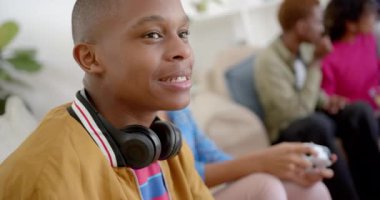 Kanepede oturup evde video oyunu oynayan çeşitli genç arkadaşlar grubunuz kutlu olsun. Gen Z, arkadaşlık, takılma, teknoloji ve yaşam tarzı, değişmemiş..
