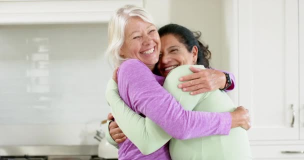 Δύο Χαρούμενες Ηλικιωμένες Γυναίκες Αγκαλιάζουν Και Χαμογελούν Στην Ηλιόλουστη Κουζίνα — Αρχείο Βίντεο