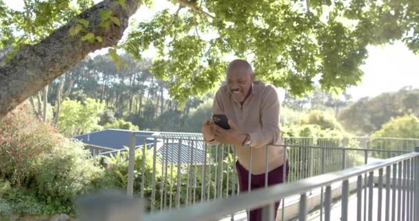 Happy Senior Biracial Man Using Smartphone Balcony Home Slow Motion — Stock video