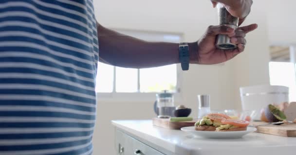 Африканский Американец Приправляет Тосты Авокадо Солнечной Кухне Замедленная Съемка Home — стоковое видео