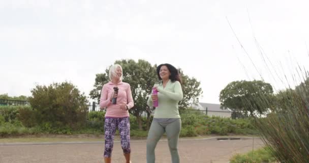 Dos Diversas Mujeres Mayores Caminando Con Botellas Agua Hablando Día — Vídeo de stock