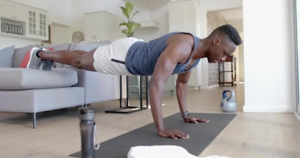 专注于非洲裔美国人做俯卧撑沙发在阳光充足的客厅 慢动作 健身和健康的生活方式 — 图库视频影像