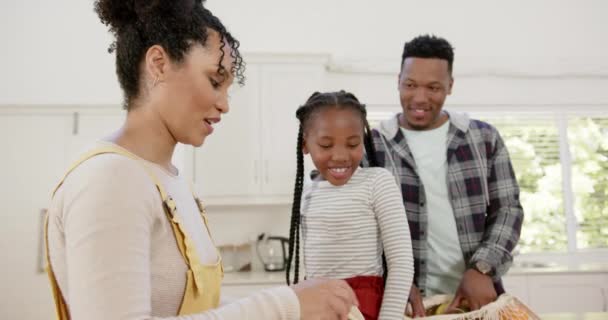 Šťastní Afroameričtí Rodiče Dcera Vybalují Nákupní Tašku Doma Zpomaleně Domácí — Stock video