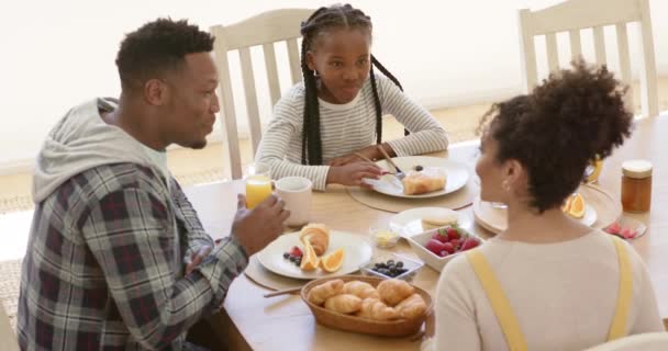 ハッピーアフリカ系アメリカ人の両親と娘は 自宅で朝食をとり ゆっくりとした動きをしています 家庭生活 食べ物 ライフスタイル 変わらない — ストック動画