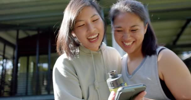 Şişesi Akıllı Telefonlu Mutlu Asyalı Bayan Arkadaşlar Terasta Gülüyorlar Ağır — Stok video
