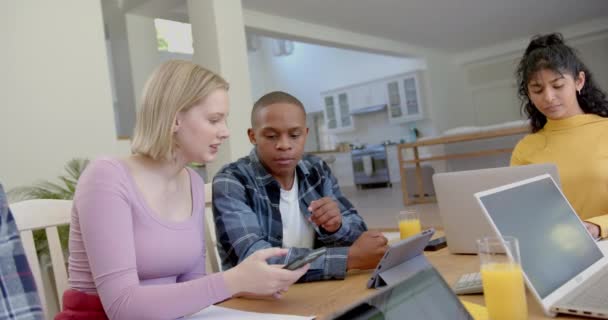 Różnorodna Grupa Nastoletnich Przyjaciół Uczących Się Przy Stole Tabletkami Smartfonem — Wideo stockowe