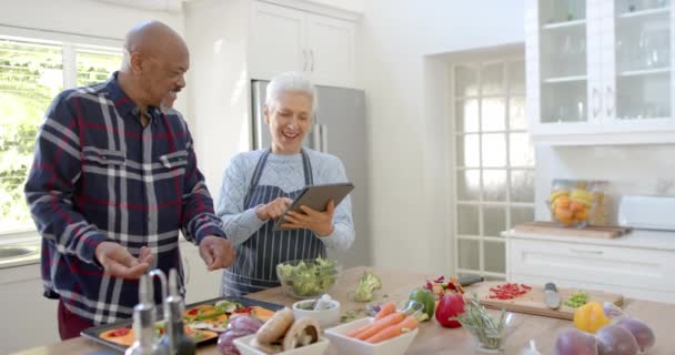 キッチン コピースペース スローモーションでタブレットを使用して野菜を準備する多種多様なシニアカップ コミュニケーション 家庭生活 食べ物 健康的なライフスタイル — ストック動画