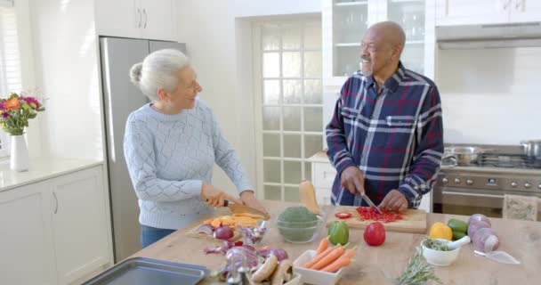 Ευτυχισμένο Ζευγάρι Ηλικιωμένων Που Μιλάει Και Κόβει Λαχανικά Στην Κουζίνα — Αρχείο Βίντεο