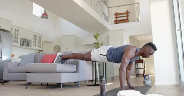 アフリカ系アメリカ人男性が 陽気なリビングルームのソファーで 動きが遅くなりました ホーム フィットネスと健康的なライフスタイル 変更されていない — ストック動画