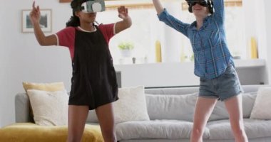 Evde oynayan ve VR kulaklık takan çeşitli genç bayan arkadaşlar, yavaş çekim. Aile hayatı, arkadaşlık, teknoloji ve yaşam tarzı, değişmedi..