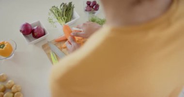 Çeşitli çiftler mutfakta taze sebzeleri hazırlıyor ve yıkıyor, yavaş çekimde. Sağlıklı, diyet, ev hayatı, yemek pişirme, yemek ve yaşam tarzı, değişmemiş.