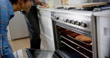 Mutfakta yemek pişiren ve pizza pişiren çeşitli genç arkadaşlar grubu, yavaş çekim. Gen z, arkadaşlık, takılma, yemek ve yaşam tarzı, değişmemiş.