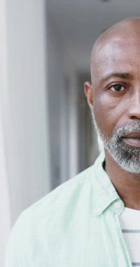 Yetişkin Afro-Amerikan bir adamın yarı portresi. Evinde gülümsüyor. Kopya alanı, ağır çekim. Mutluluk, ev hayatı ve yaşam tarzı, değişmedi..