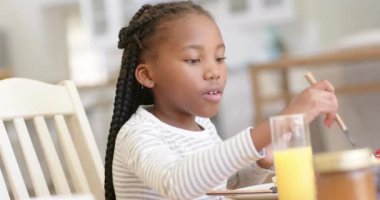 Mutlu Afro-Amerikan baba ve kızları kahvaltılarını evde yapıyorlar, ağır çekimde. Aile hayatı, yemek, aile ve yaşam tarzı, değiştirilmemiş..