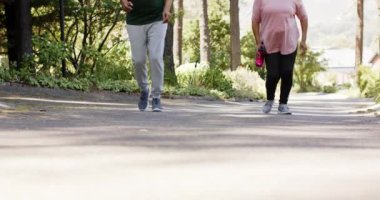 Güneşli havada koşan ve su şişesi tutan çeşitli yaşlı çiftler. Emeklilik, boş zaman, sağlıklı yaşam tarzı, birliktelik ve doğa konsepti, değişmemiş..
