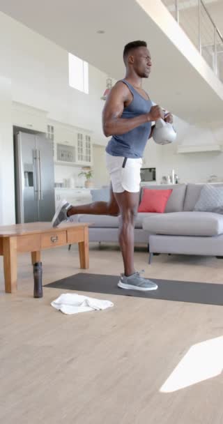 Homem Afro Americano Focado Exercitar Com Kettlebell Sala Estar Ensolarada — Vídeo de Stock
