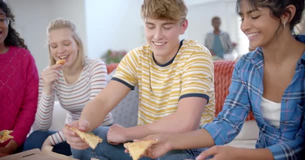Glad Varierande Grupp Tonårsvänner Sitter Soffan Och Äter Pizza Hemma — Stockvideo