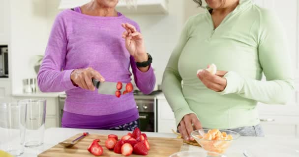 Două Femei Vârstă Fericite Care Taie Fructe Discută Zâmbesc Bucătăria — Videoclip de stoc
