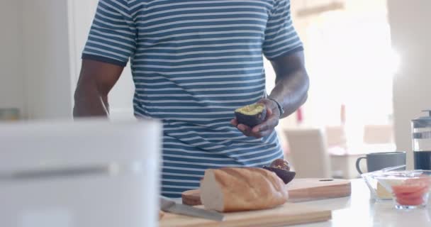 Afrikanischer Mann Bereitet Sonniger Küche Avocado Toasts Zeitlupe Haus Haushalt — Stockvideo