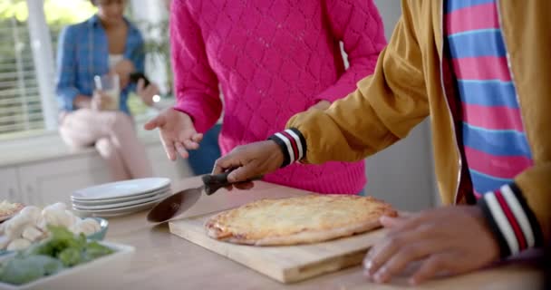 Счастливая Разносторонняя Группа Друзей Подростков Готовит Нарезает Пиццу Кухне Замедляет — стоковое видео