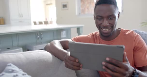 Szczęśliwy Afroamerykanin Siedzący Korzystający Tabletu Słonecznym Salonie Zwolnionym Tempie Dom — Wideo stockowe