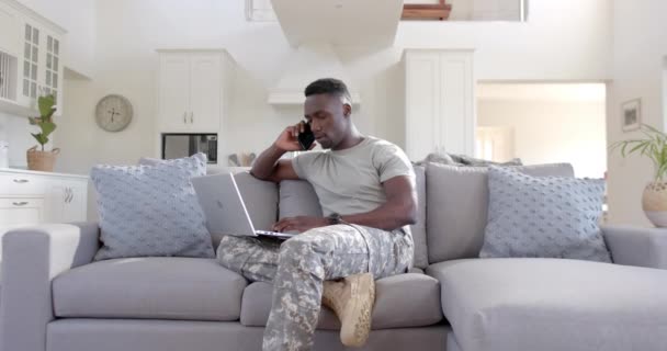 Drukke Afrikaanse Amerikaanse Mannelijke Soldaat Met Behulp Van Smartphone Laptop — Stockvideo