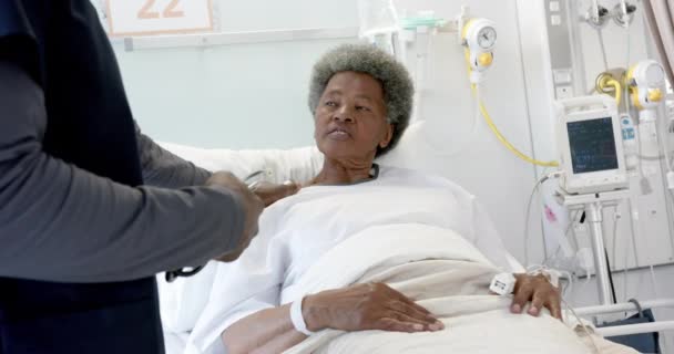 African American Male Doctor Talking Female Senior Patient Hospital Room — Stock Video