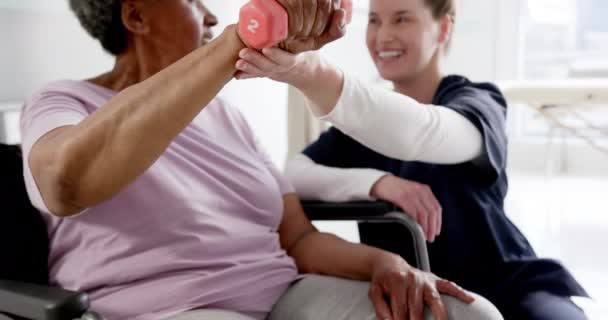 Diverse Seniorin Die Mit Gewicht Trainiert Und Ärztin Krankenhaus Berät — Stockvideo
