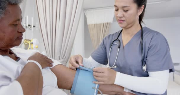 Різні Лікарі Жінки Випробовують Кров Яний Тиск Старшої Жінки Пацієнта — стокове відео