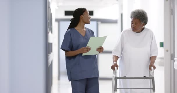Αφροαμερικανή Γιατρός Και Ηλικιωμένη Γυναίκα Πατερίτσες Περπατάνε Στο Νοσοκομείο Αργή — Αρχείο Βίντεο