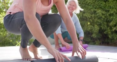 İki mutlu yaşlı kadın paspasları sarıp güneşli bahçede tartışıyor, ağır çekimde. Arkadaşlar, emeklilik, fitness, refah, ev hayatı ve yaşlılar yaşam tarzı, arkadaşlık, değişmemiş.