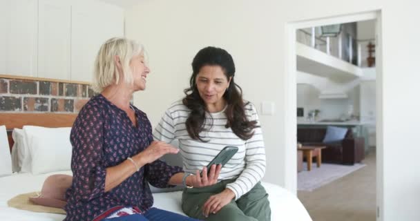 Două Femei Vârstă Fericite Folosind Smartphone Râzând Dormitorul Însorit Mișcându — Videoclip de stoc