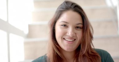 Evdeki güneşli odada gülümseyen mutlu, iri yarı, çift ırklı bir kadının portresi, yavaş çekim. Mutluluk, ev hayatı ve sağlıklı yaşam tarzı, değişmemiş..