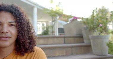 Güneşli bahçede gülümseyen uzun saçlı mutlu, melez bir adamın yarı portresi, fotokopi alanı. Yaz, doğa, ev hayatı ve yaşam tarzı, değişmedi..