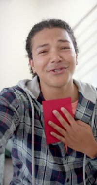 Mutlu, çift ırklı bir adamın video görüşmesine ve öpüşmesine ait dikey video, yavaş çekim. İletişim, doğum günü, sevgililer günü, kutlama, romantizm ve yaşam tarzı, değişmemiş.