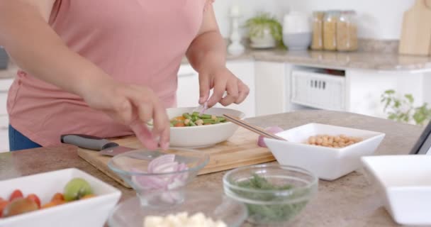 キッチンで野菜と食事をするプラスサイズの女性のミックス スローモーション 食べ物 家庭生活 健康的なライフスタイル 変わらない — ストック動画
